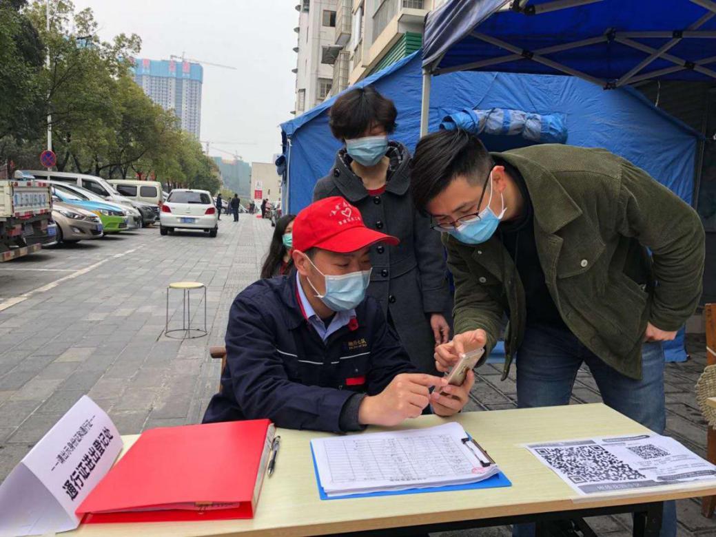 在宜昌地质花苑小区，下沉党员赵小明（左）在小区卡点值守